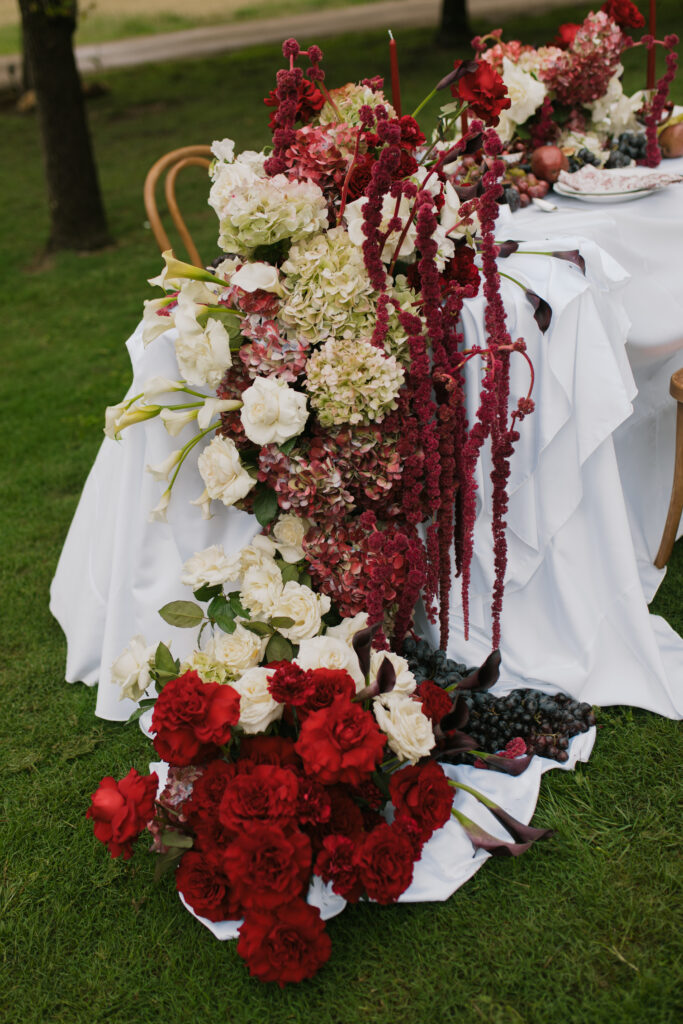 Editorial wedding dinner setup with grapes, fruit, and candlelight details