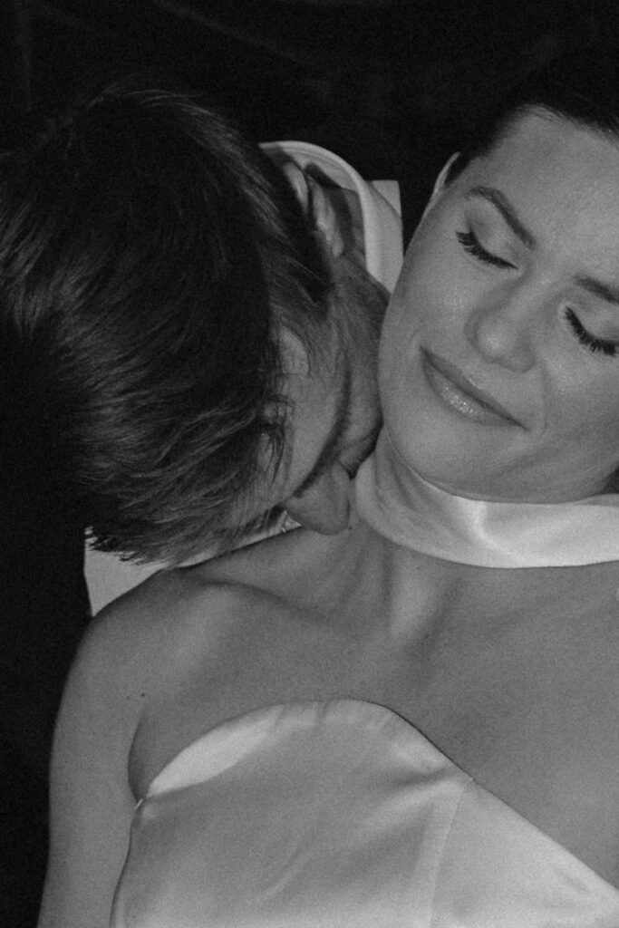 Emily and Patrick embracing during red draped editorial wedding shoot